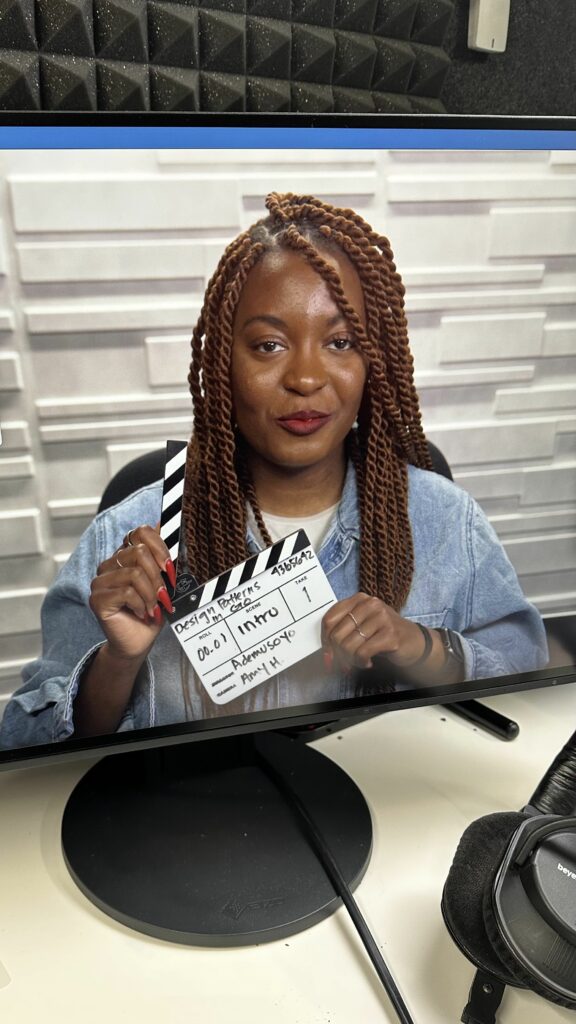 Ademusoyo, a productivity and notion template creator and consultant is pictured holding a small clapperboard while recording her new LinkedIn Learning course.