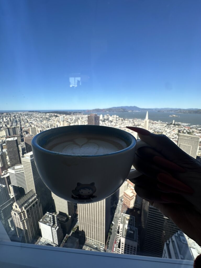 A productivity & notion expert woman holding a cup of coffee with a backdrop of buildings in San Francisco 